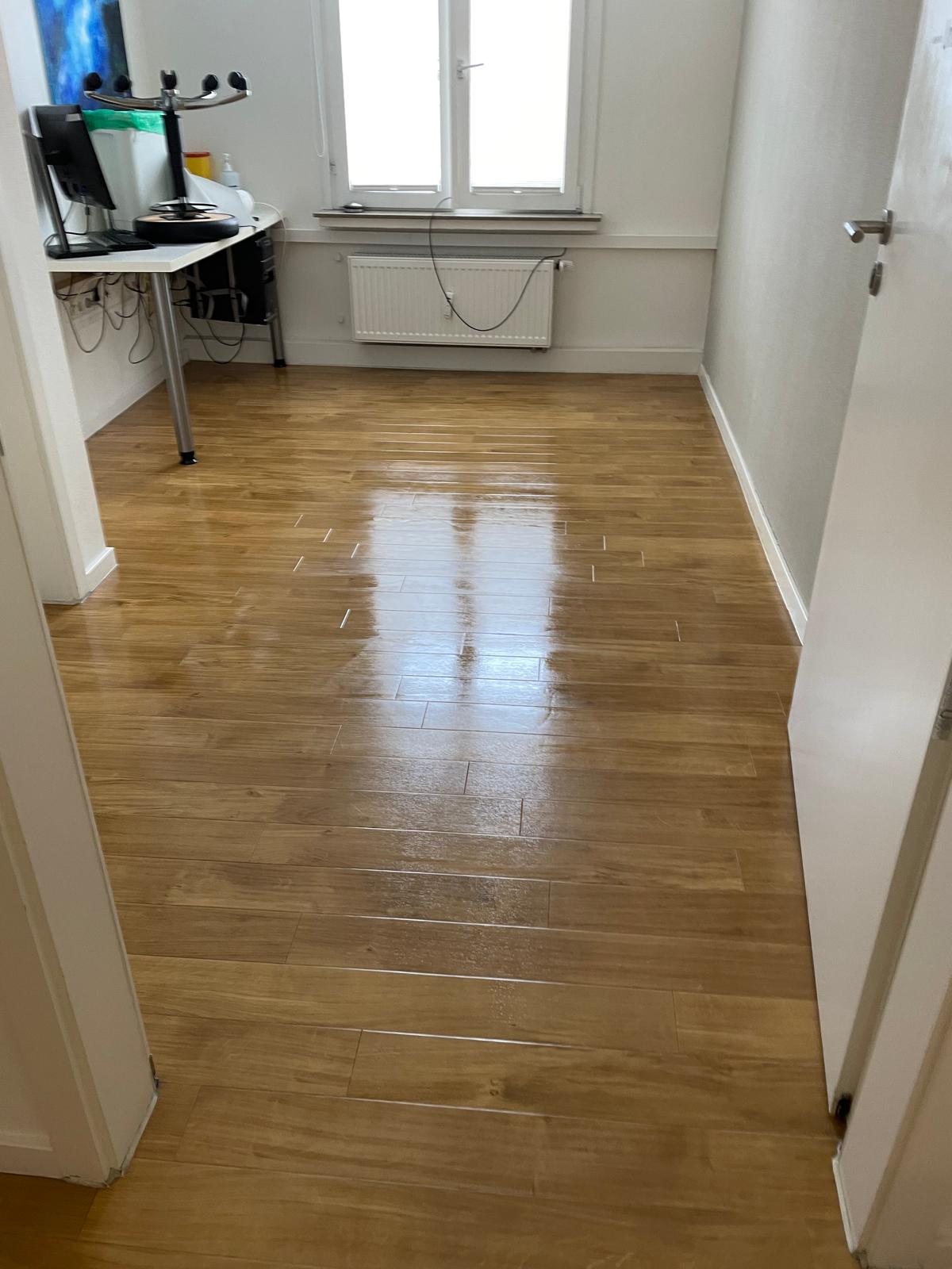Frisch gereinigter, glänzender Parkettboden in einem Büro